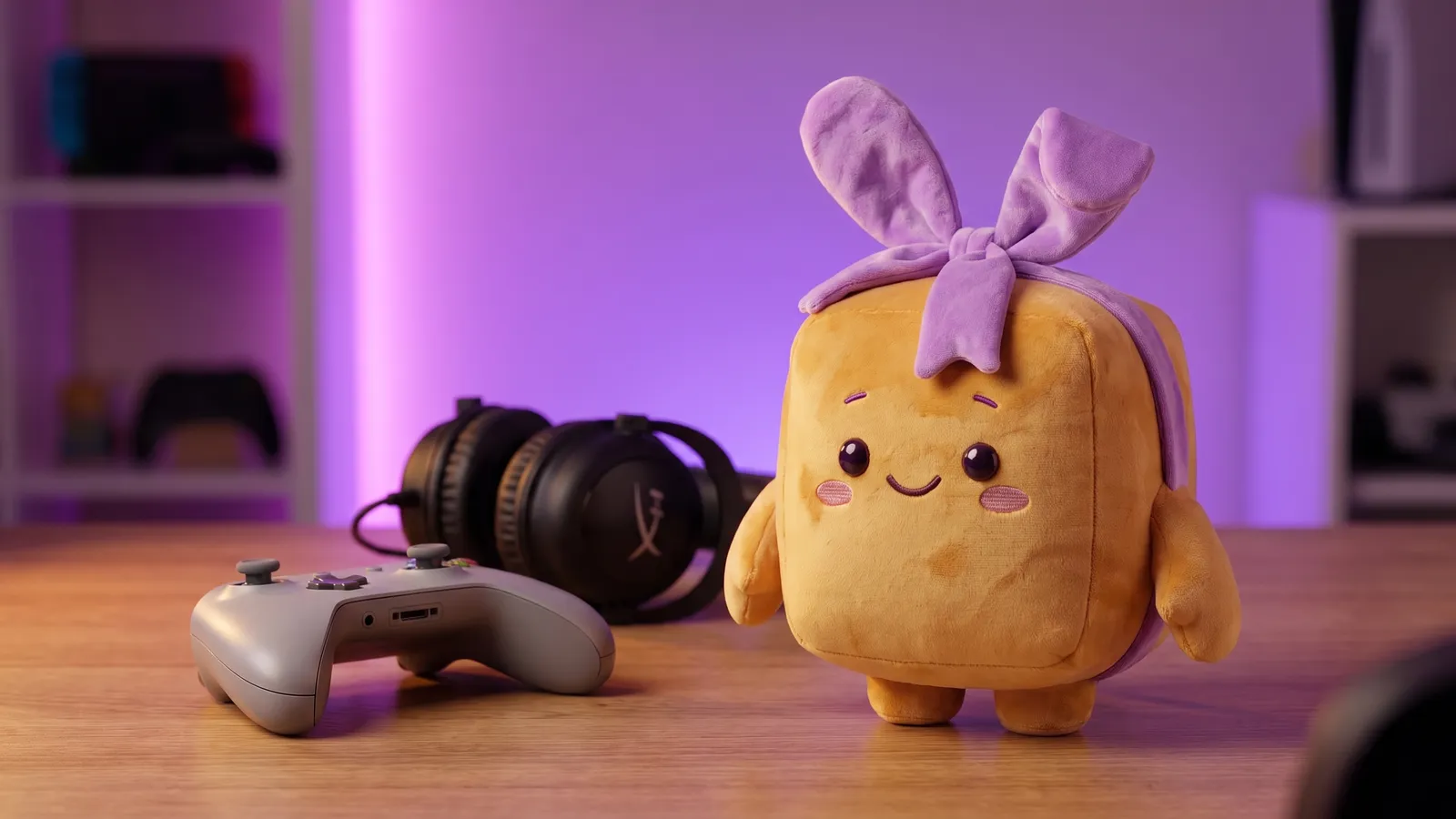 Schenky am Gaming-Schreibtisch neben Controller und Headset im lila Licht